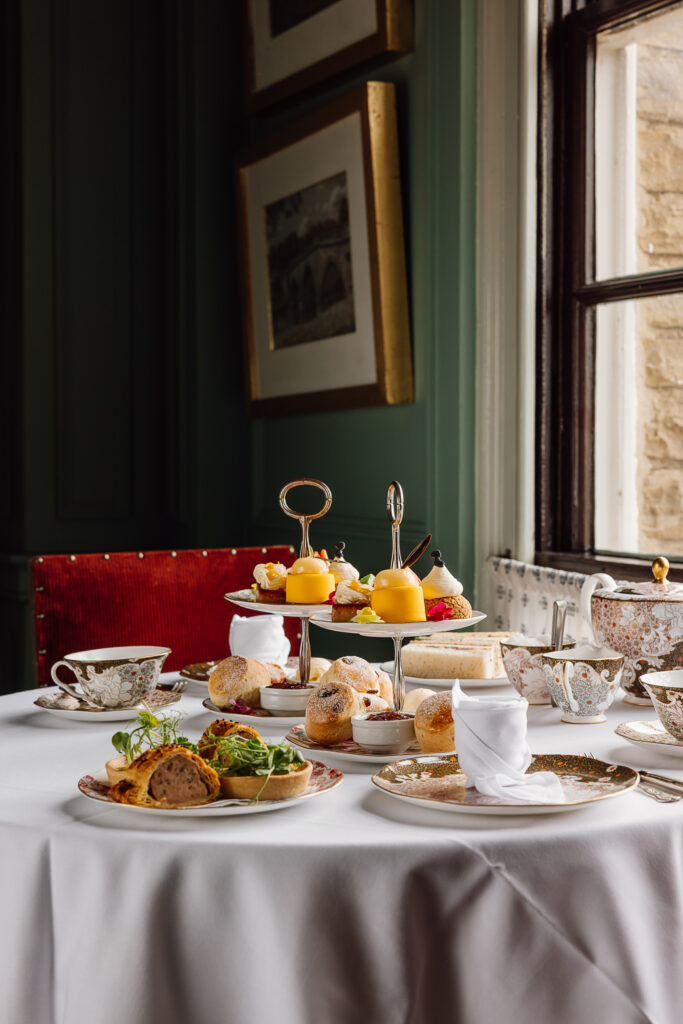 A selection of sandwiches and sweet treats on fine china, with tea.
