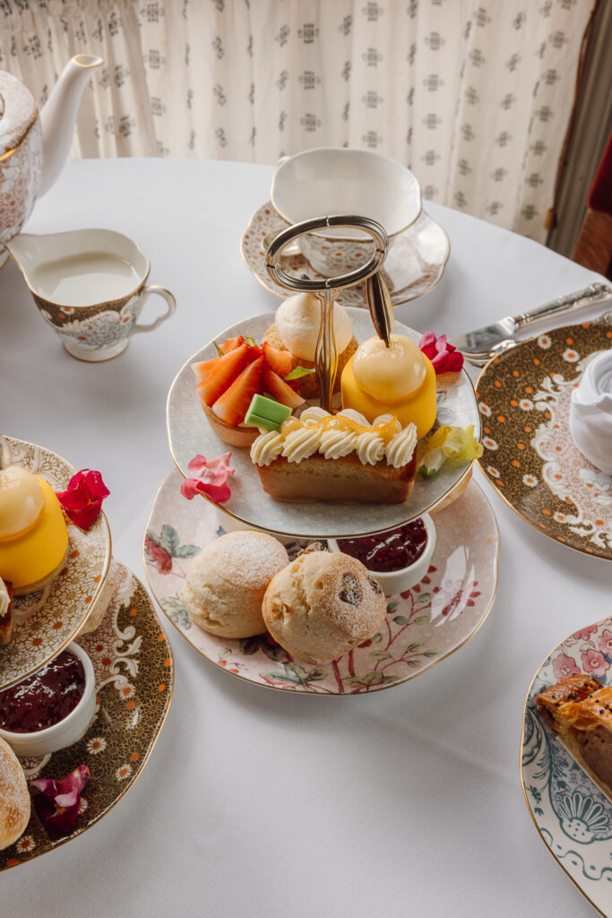 A selection of sandwiches and sweet treats on fine china.