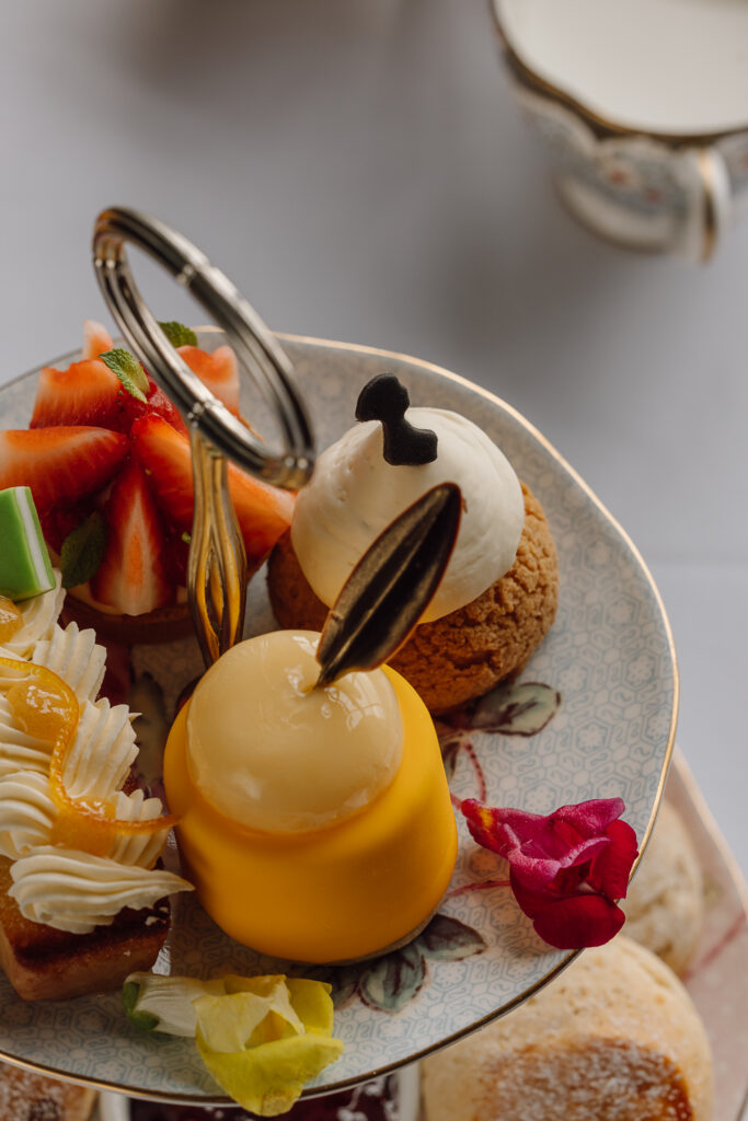 A selection of sweet treats on a fine china afternoon tea stand.