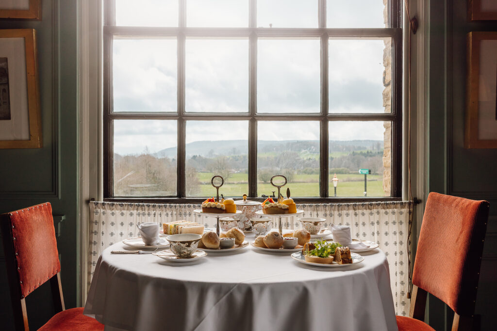 A selection of sandwiches and sweet treats on fine china, with tea.